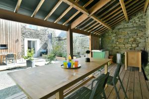 a patio with a wooden table and chairs at Ty Karet - Maison pour 6 proche plage in Saint-Cast-le-Guildo