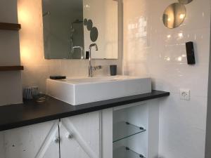 biała łazienka z umywalką i lustrem w obiekcie Ty Karet - Maison pour 6 proche plage w mieście Saint-Cast-le-Guildo +11 zdjęć