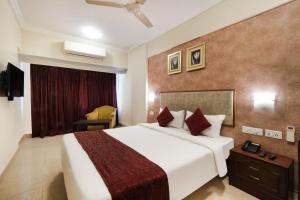 a hotel room with a bed and a television at 7 Apple Hotel Pimpri Pune in Pune