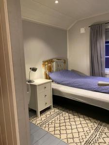 a bedroom with a bed and a table with a lamp at Close to sea, central, rent a boat, mountain hike, wifi, free parking in Haug