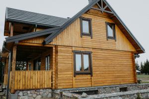 Cabaña de madera con techo negro en Chata Krusznia en Giby