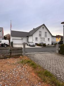 ein weißes Haus mit einem Auto, das in einer Einfahrt parkt in der Unterkunft Studio-Appartement Neunburg vorm Wald in Neunburg vorm Wald