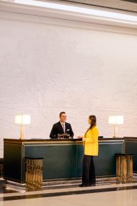 a man and a woman standing at a desk at Fairmont Amman in Amman