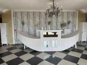 bañera blanca en una habitación con suelo a cuadros en Krzewi Róg, en Garcz