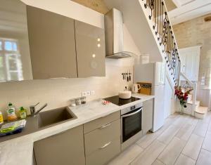 a kitchen with white cabinets and a sink at La Montgrande, 2 bed gîte, Aulnay in Aulnay