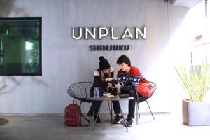 two people sitting at a table in front of a store at UNPLAN Shinjuku in Tokyo