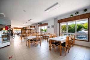 a dining room with tables and chairs in a restaurant at Camping Baltar in Portonovo
