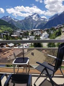 a balcony with two chairs and a view of mountains at Magnifique Vue Centre Station in Les Deux Alpes