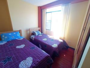 a bedroom with two beds and a window at Departamento cerca al centro de Huancayo. in Huancayo