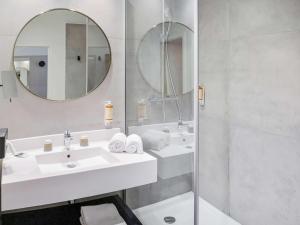 a bathroom with two sinks and a mirror at Mercure Bourg En Bresse in Bourg-en-Bresse
