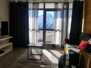 a living room with a couch and a large window at Magnifique Vue Centre Station in Les Deux Alpes