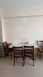 a dining room table and chairs with a white table at Wjbca Staycation in Tagaytay