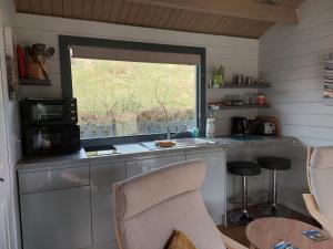 a kitchen with a window and a counter with a microwave at CROFTERS CABIN in Bracadale