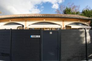 Ein schwarzer Zaun mit einem Tor vor einem Haus. in der Unterkunft Le clos de Tanvol 2 -parking gratuit- climatisation-terrasse in Viriat