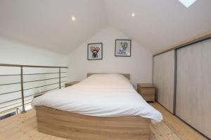 ein Schlafzimmer mit einem großen Bett mit weißer Bettwäsche in der Unterkunft Le clos de Tanvol 2 -parking gratuit- climatisation-terrasse in Viriat
