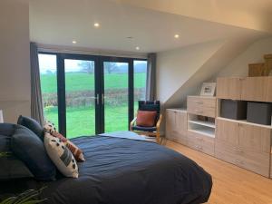 a bedroom with a large bed with a large window at Ridgeway View in Pembrokeshire
