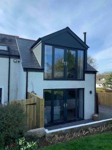a house with a black roof and glass windows at Ridgeway View in Pembrokeshire