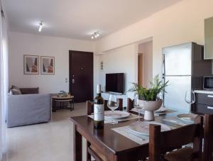 a kitchen and living room with a table with wine glasses at Apartment Santa Marina 5 in Asgourou
