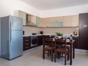 a kitchen with a refrigerator and a table with chairs at Apartment Santa Marina 5 in Asgourou