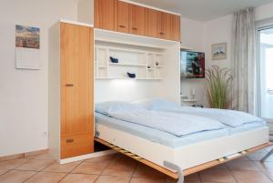 a bedroom with a bed and a cabinet at Haus Hanseatic, Wohnung 109 in Duhnen