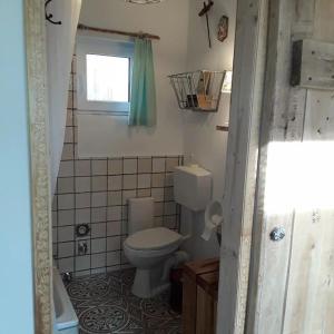 a small bathroom with a toilet and a window at Ferienhaus mit Minibauernhof in Munster im Heidekreis
