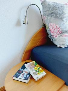 a book on a table next to a bed with a lamp at Helles Apartment mit Balkon am Großen Garten nahe Stadtzentrum in Dresden