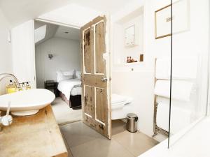 un bagno con porta aperta, lavandino e letto di Monachyle Mhor Hotel a Lochearnhead
