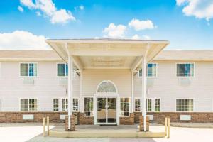 a large white building with a gambrel roof at Super 8 by Wyndham Platte City Kansas City Area in Platte City