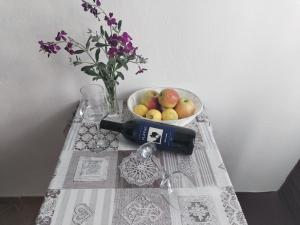 a table with a bowl of fruit and a bottle of wine at Apartments Patricija in Polače
