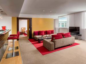 a living room with a couch and red pillows at Novotel Bucharest City Centre in Bucharest