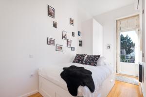 a bedroom with a bed with a black robe on it at MARKES · Lovely 1-bedroom home w/ sunny backyard in Porto