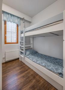 a bedroom with two bunk beds and a wooden floor at Länsirinne 9 C in Ruka