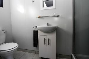 a white bathroom with a sink and a toilet at SleepOver KMIA in White River