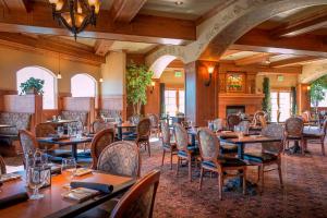 a restaurant with tables and chairs and a fireplace at Zermatt Utah Resort & Spa Trademark Collection by Wyndham in Midway