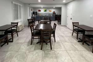Quality Inn & Suites في كولومبوس: غرفة طعام مع طاولات وكراسي ومطبخ
