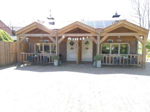 einem Holzpavillon mit Tischen und Stühlen im Hof in der Unterkunft Logies De Houtdijk in Harich