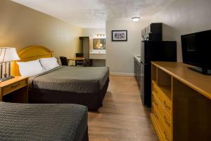 a hotel room with two beds and a flat screen tv at Suburban Studios Brazil in Brazil