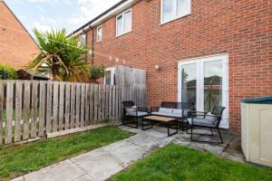 a patio with a table and chairs in front of a brick building at Grange Way in Bowburn