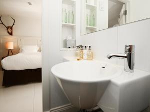 a white bathroom with a sink and a bed at Monachyle Mhor Hotel in Lochearnhead +94 photos