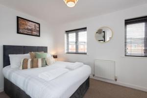 a bedroom with a large white bed with windows at Grange Way in Bowburn