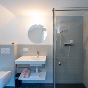 a bathroom with a sink and a shower at Gasthof Löwen Tosters in Feldkirch