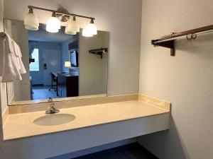 baño con lavabo y espejo grande en Motel 6 Forrest City AR, en Forrest City