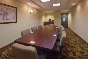 a conference room with a large wooden table and chairs at Wingate By Wyndham in Mansfield