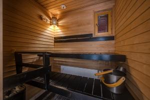a sauna with wooden walls and a bucket at Länsirinne 9 C in Ruka +7 photos