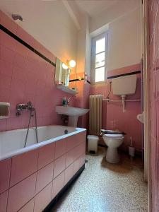 Baño de color rosa con lavabo, bañera y aseo en Vassilikon Hotel, en Loutraki