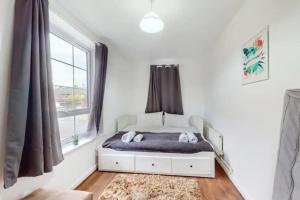 a bedroom with a bed and a window at Central & Cosy 2BD Flat near Canary Wharf in London