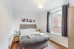 a bedroom with a bed with two pillows on it at Central & Cosy 2BD Flat near Canary Wharf in London