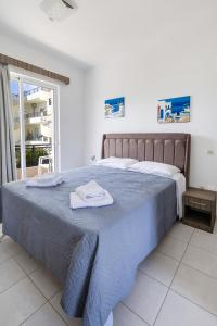 a bedroom with a large bed with towels on it at Johnhara Studios & Apartments in Ialysos