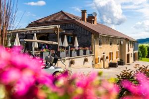 un bâtiment avec des parasols et des fleurs devant lui dans l'établissement Golf du Rochat, aux Rousses