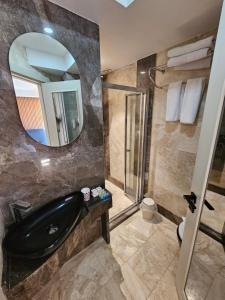 baño con bañera negra y espejo en Anthemis Hotel, en Estambul